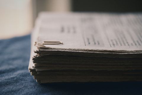 A stack of paper documents with a paper clip, softly out of focus